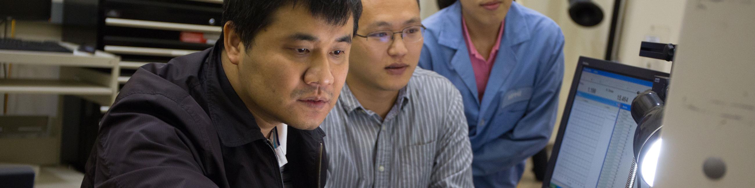 Three researchers collaborating in a lab.