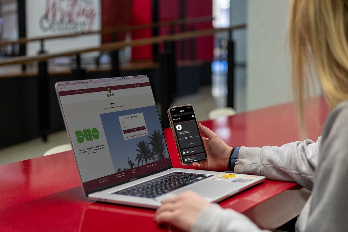 A female student accepting her DUO push notification for her laptop.