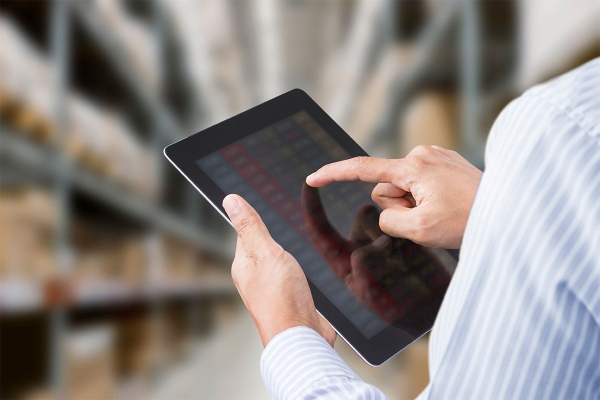 A close up of a man working on a tablet.