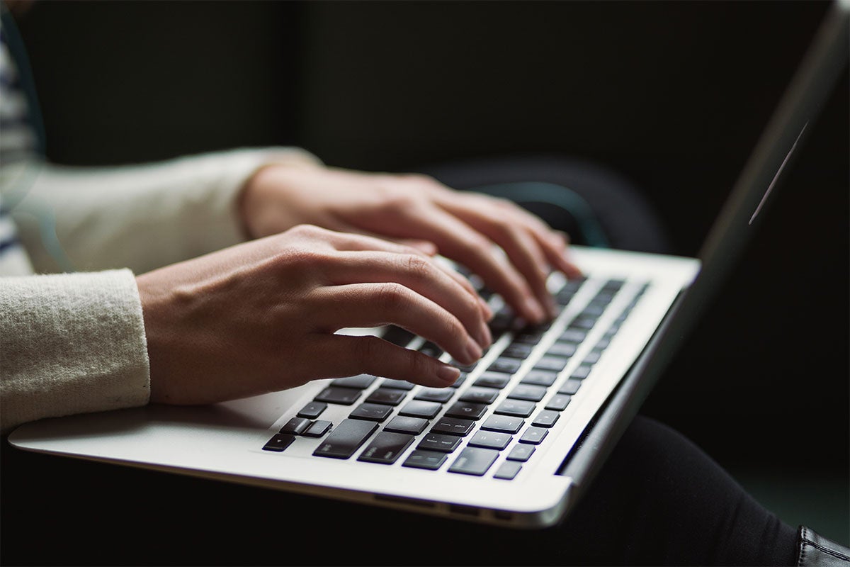 A close up of someone working on their laptop. 