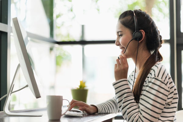 Woman speaking on computer with headset