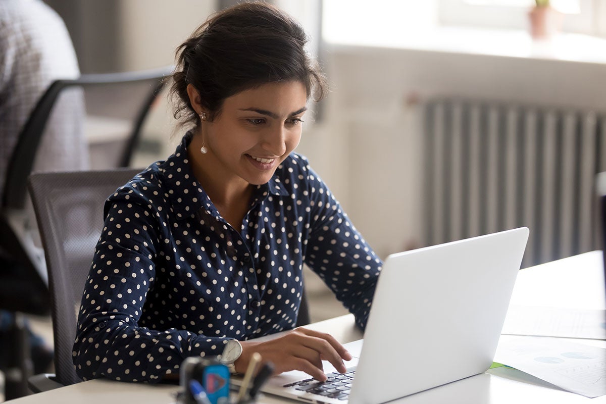 A female working on her laptop in her office. 