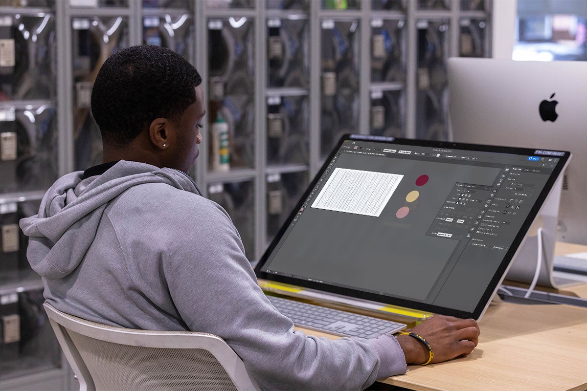 A male computer designing a graphic on a desktop computer.